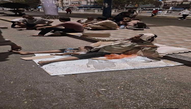 صورة تختصر معاناة عدن.. أب يفترش الشارع حاملاً طفله هربًا من الحر وانقطاع الكهرباء